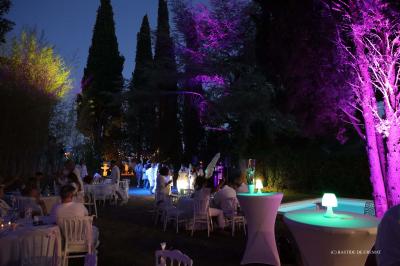 Chambre avec un lit double, éclairage doux et une grande bibliothèque en bois remplie de livres en arrière-plan.