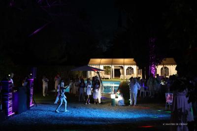 Chambre avec un lit double, éclairage doux et une grande bibliothèque en bois remplie de livres en arrière-plan.