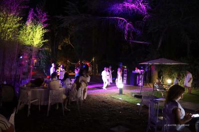 Chambre avec un lit double, éclairage doux et une grande bibliothèque en bois remplie de livres en arrière-plan.