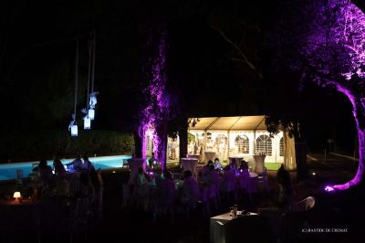 Chambre avec un lit double, éclairage doux et une grande bibliothèque en bois remplie de livres en arrière-plan.