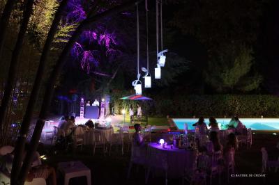 Chambre avec un lit double, éclairage doux et une grande bibliothèque en bois remplie de livres en arrière-plan.