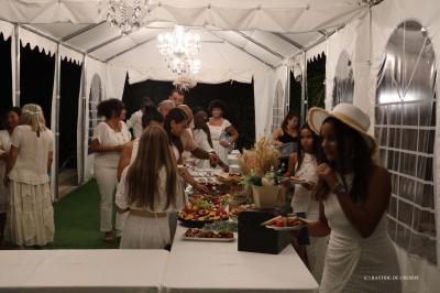 Chambre avec un lit double, éclairage doux et une grande bibliothèque en bois remplie de livres en arrière-plan.