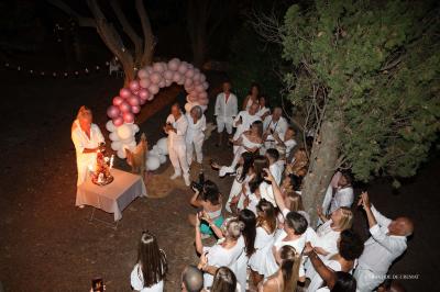 Chambre avec un lit double, éclairage doux et une grande bibliothèque en bois remplie de livres en arrière-plan.