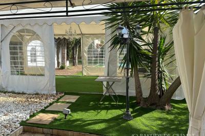 Chambre avec un lit double, éclairage doux et une grande bibliothèque en bois remplie de livres en arrière-plan.