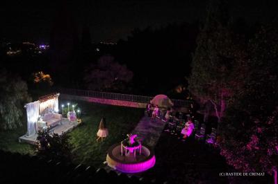 Chambre avec un lit double, éclairage doux et une grande bibliothèque en bois remplie de livres en arrière-plan.
