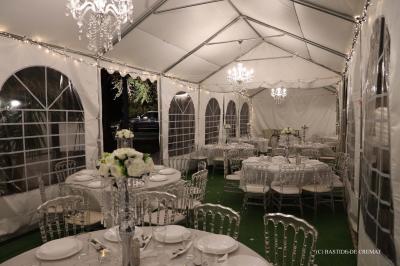 Chambre avec un lit double, éclairage doux et une grande bibliothèque en bois remplie de livres en arrière-plan.