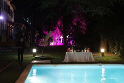 Chambre avec un lit double, éclairage doux et une grande bibliothèque en bois remplie de livres en arrière-plan.