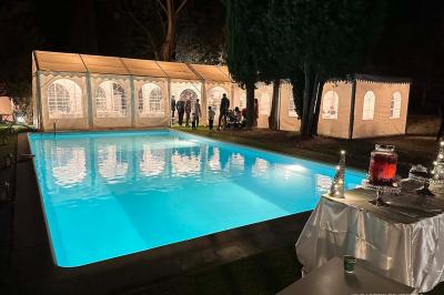 Chambre avec un lit double, éclairage doux et une grande bibliothèque en bois remplie de livres en arrière-plan.