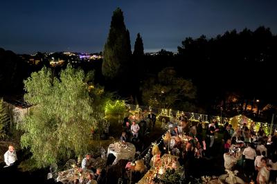 Chambre avec un lit double, éclairage doux et une grande bibliothèque en bois remplie de livres en arrière-plan.
