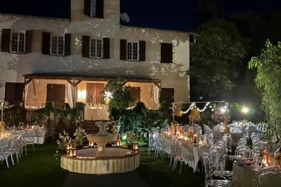 Chambre avec un lit double, éclairage doux et une grande bibliothèque en bois remplie de livres en arrière-plan.