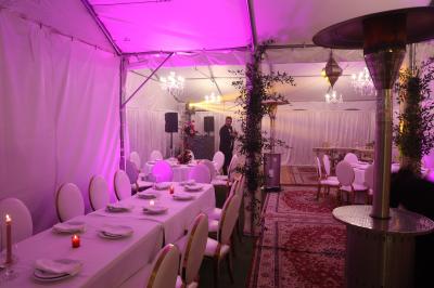 Chambre avec un lit double, éclairage doux et une grande bibliothèque en bois remplie de livres en arrière-plan.