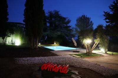 Chambre avec un lit double, éclairage doux et une grande bibliothèque en bois remplie de livres en arrière-plan.