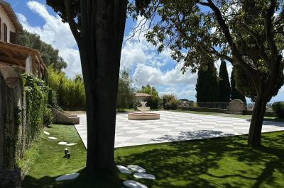 Chambre avec un lit double, éclairage doux et une grande bibliothèque en bois remplie de livres en arrière-plan.