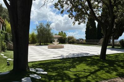 Chambre avec un lit double, éclairage doux et une grande bibliothèque en bois remplie de livres en arrière-plan.