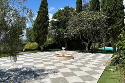 Chambre avec un lit double, éclairage doux et une grande bibliothèque en bois remplie de livres en arrière-plan.