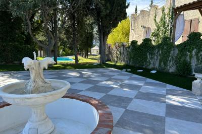 Chambre avec un lit double, éclairage doux et une grande bibliothèque en bois remplie de livres en arrière-plan.
