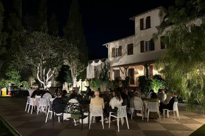 Chambre avec un lit double, éclairage doux et une grande bibliothèque en bois remplie de livres en arrière-plan.