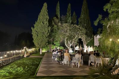 Chambre avec un lit double, éclairage doux et une grande bibliothèque en bois remplie de livres en arrière-plan.