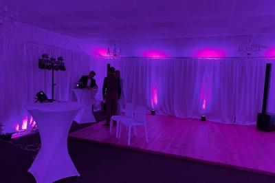 Chambre avec un lit double, éclairage doux et une grande bibliothèque en bois remplie de livres en arrière-plan.