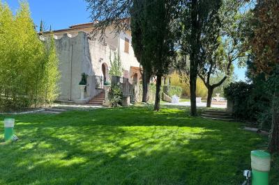 Chambre avec un lit double, éclairage doux et une grande bibliothèque en bois remplie de livres en arrière-plan.