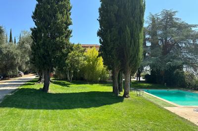 Chambre avec un lit double, éclairage doux et une grande bibliothèque en bois remplie de livres en arrière-plan.