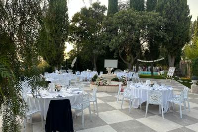 Chambre avec un lit double, éclairage doux et une grande bibliothèque en bois remplie de livres en arrière-plan.