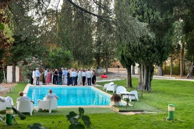 Chambre avec un lit double, éclairage doux et une grande bibliothèque en bois remplie de livres en arrière-plan.