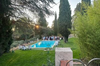 Chambre avec un lit double, éclairage doux et une grande bibliothèque en bois remplie de livres en arrière-plan.