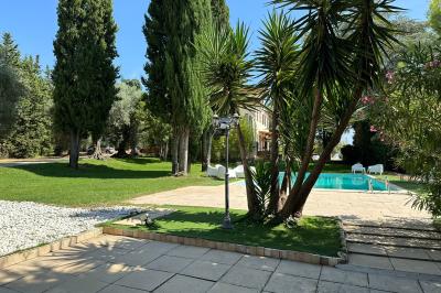 Chambre avec un lit double, éclairage doux et une grande bibliothèque en bois remplie de livres en arrière-plan.