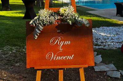 Chambre avec un lit double, éclairage doux et une grande bibliothèque en bois remplie de livres en arrière-plan.