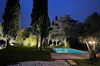 Chambre avec un lit double, éclairage doux et une grande bibliothèque en bois remplie de livres en arrière-plan.