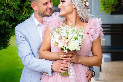 Ours en peluche avec un nœud rose devant un présentoir de cupcakes décorés dans un décor rose et lumineux.