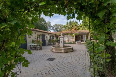 Un couple de mariés lève les bras en l'air devant des invités lors d'une réception en extérieur près d'une piscine.