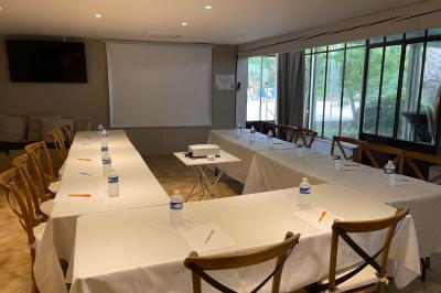 Un couple de mariés lève les bras en l'air devant des invités lors d'une réception en extérieur près d'une piscine.