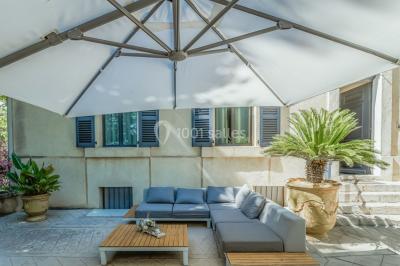 Table décorée avec des bougies allumées, des fleurs séchées et fraîches dans des vases, sur fond de rideaux blancs.