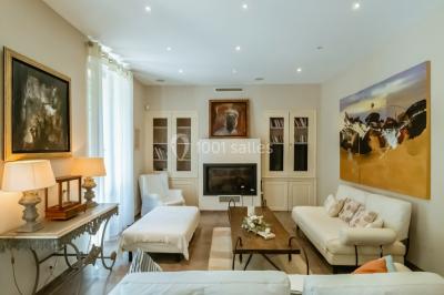 Table décorée avec des bougies allumées, des fleurs séchées et fraîches dans des vases, sur fond de rideaux blancs.