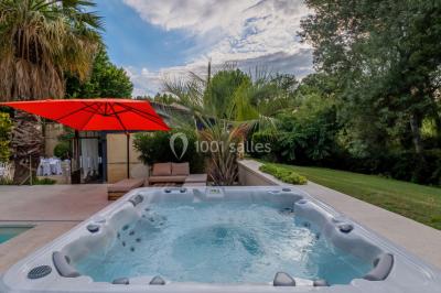 Table décorée avec des bougies allumées, des fleurs séchées et fraîches dans des vases, sur fond de rideaux blancs.