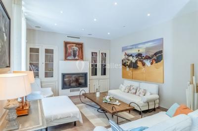 Table décorée avec des bougies allumées, des fleurs séchées et fraîches dans des vases, sur fond de rideaux blancs.