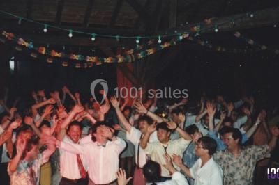 Miniature DJ Biscarrosse (Landes) - S&P DJ Animation #4 Salle sombre avec des poutres en bois, éclairée par des lumières colorées, des personnes discutent et se déplacent.