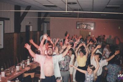 Miniature DJ Biscarrosse (Landes) - S&P DJ Animation #5 Salle sombre avec des poutres en bois, éclairée par des lumières colorées, des personnes discutent et se déplacent.