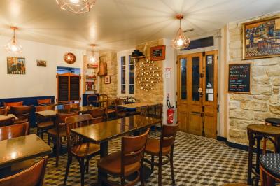 Bouteilles variées alignées sur une étagère en bois dans un bar avec une enseigne ’L'Astrolabe’ en arrière-plan.