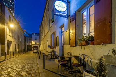 Bouteilles variées alignées sur une étagère en bois dans un bar avec une enseigne ’L'Astrolabe’ en arrière-plan.