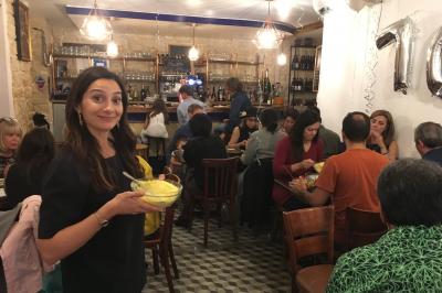 Bouteilles variées alignées sur une étagère en bois dans un bar avec une enseigne ’L'Astrolabe’ en arrière-plan.