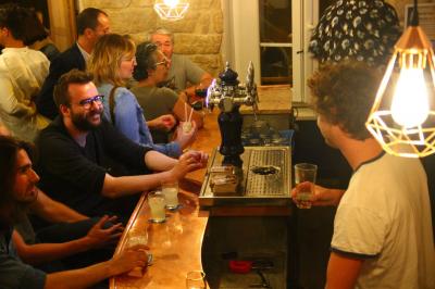 Bouteilles variées alignées sur une étagère en bois dans un bar avec une enseigne ’L'Astrolabe’ en arrière-plan.