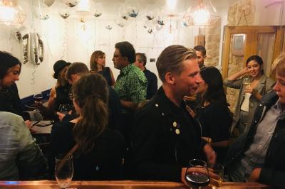 Bouteilles variées alignées sur une étagère en bois dans un bar avec une enseigne ’L'Astrolabe’ en arrière-plan.
