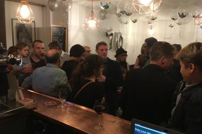 Bouteilles variées alignées sur une étagère en bois dans un bar avec une enseigne ’L'Astrolabe’ en arrière-plan.