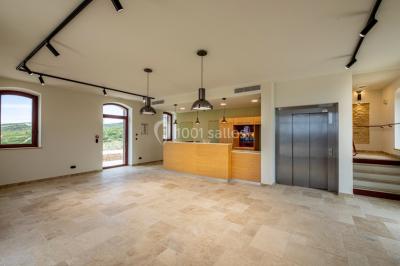 Personnes rassemblées devant une grande maison avec des tentes blanches, un brasero avec brochettes au premier plan.