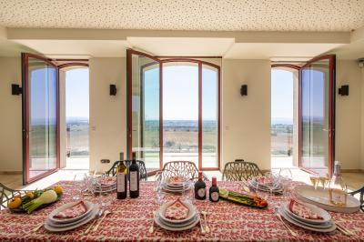 Personnes rassemblées devant une grande maison avec des tentes blanches, un brasero avec brochettes au premier plan.