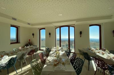 Personnes rassemblées devant une grande maison avec des tentes blanches, un brasero avec brochettes au premier plan.