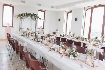 Personnes rassemblées devant une grande maison avec des tentes blanches, un brasero avec brochettes au premier plan.